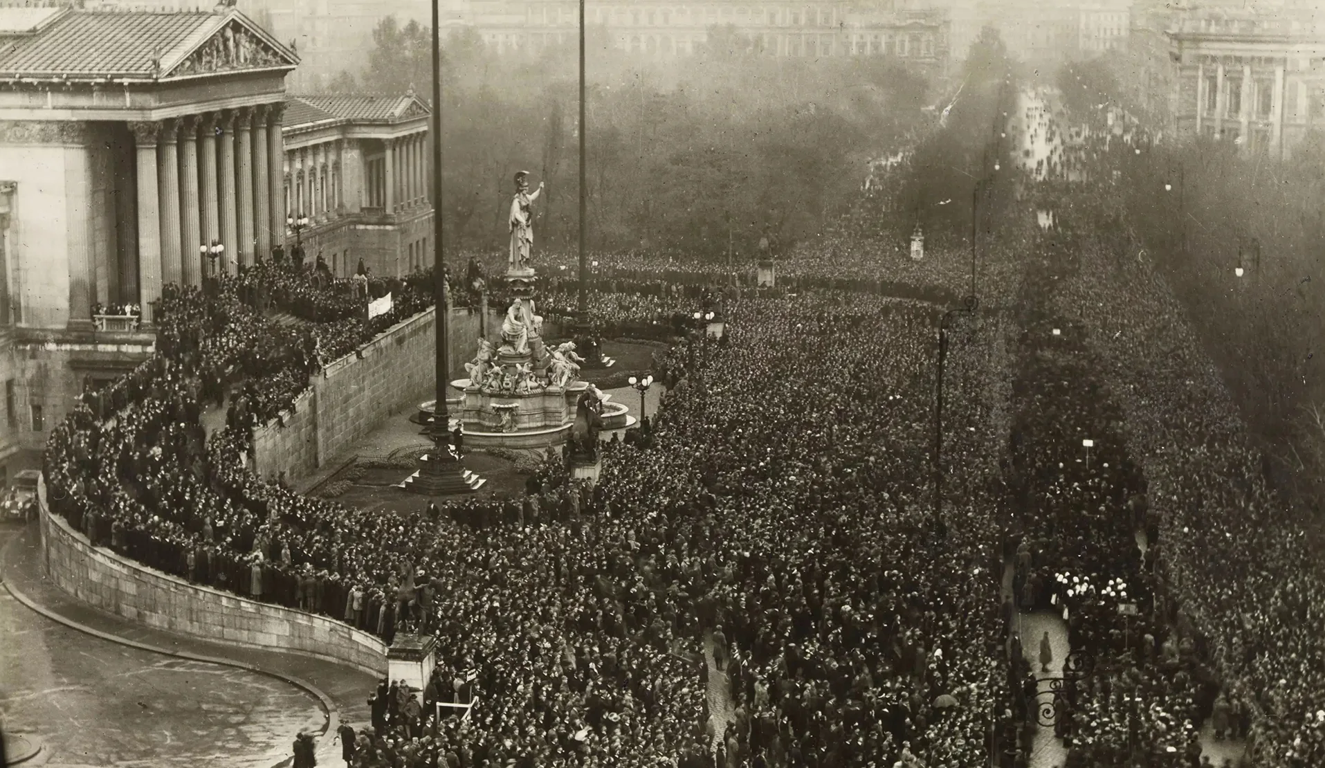 Schwarz-Weiß-Foto von dem mit Menschenmassen gefüllten Platz vor dem österreichischen Parlament