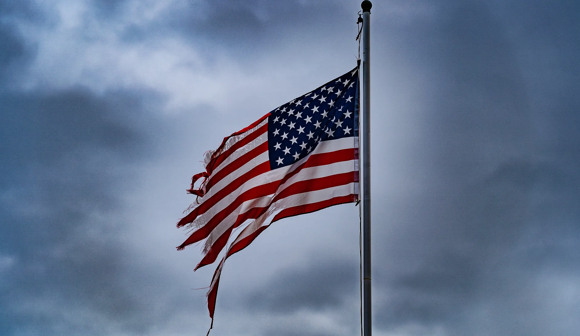 Eine halb zerfranste US-Flagge hängt an einem Flaggenmast