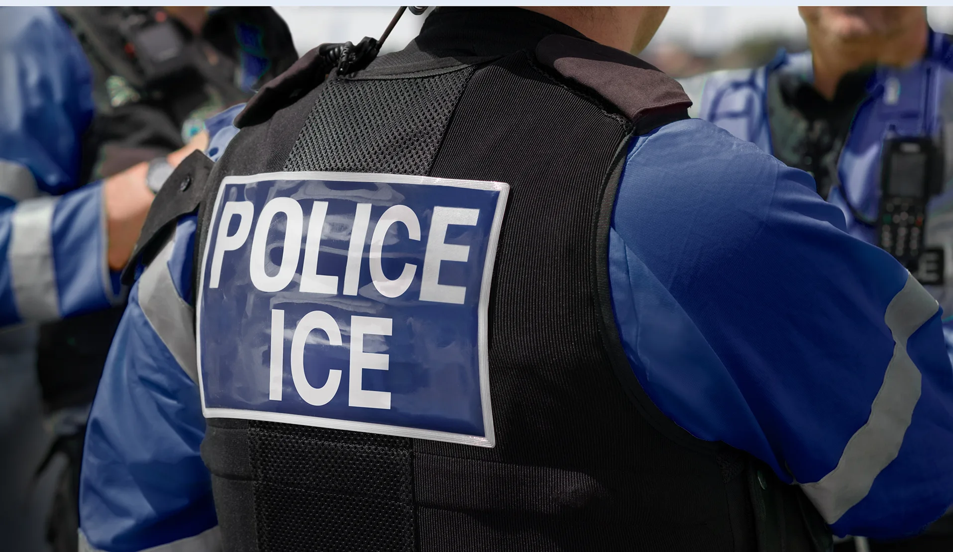 Der Rücken eines uniformierten ICE-Polizisten