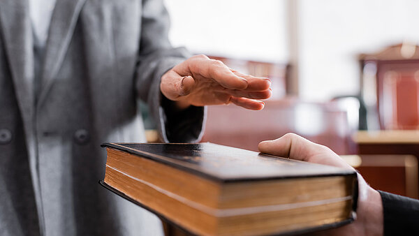Ein Mann legt seine Hand auf eine Bibel