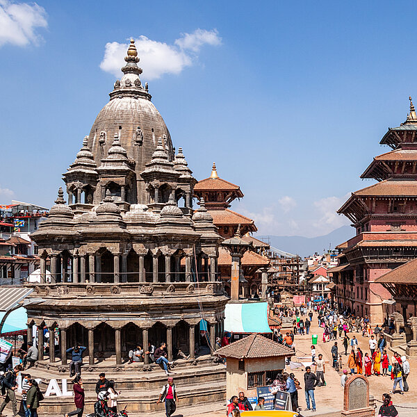 Public square with Nepalese historic buildings and pedestrians. 